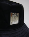 Streetwear inspired black satin bucket hat with silver EMLOTTI logo on front and back.