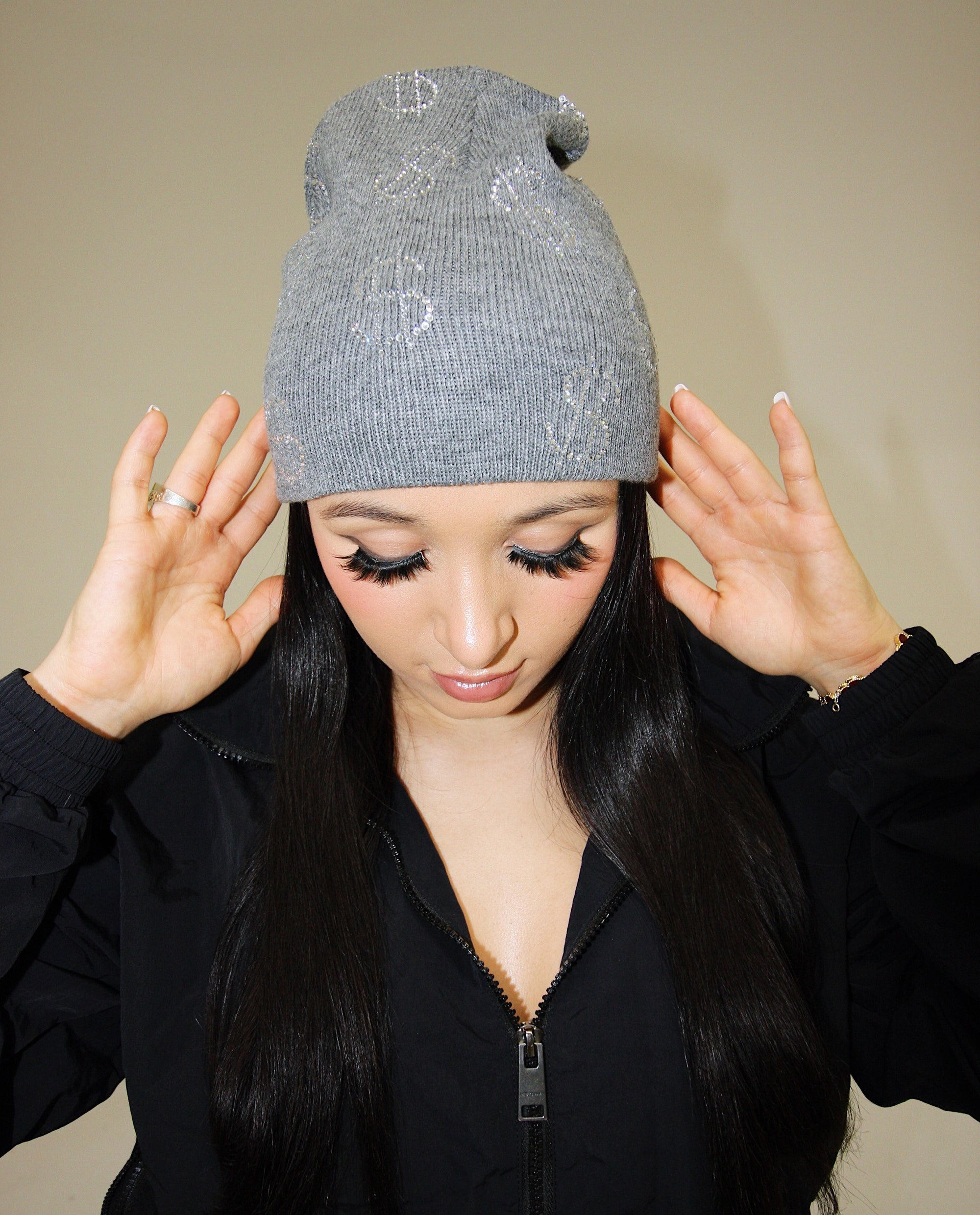 Black knit beanie with money signs in rhinestones by EMLOTTI.